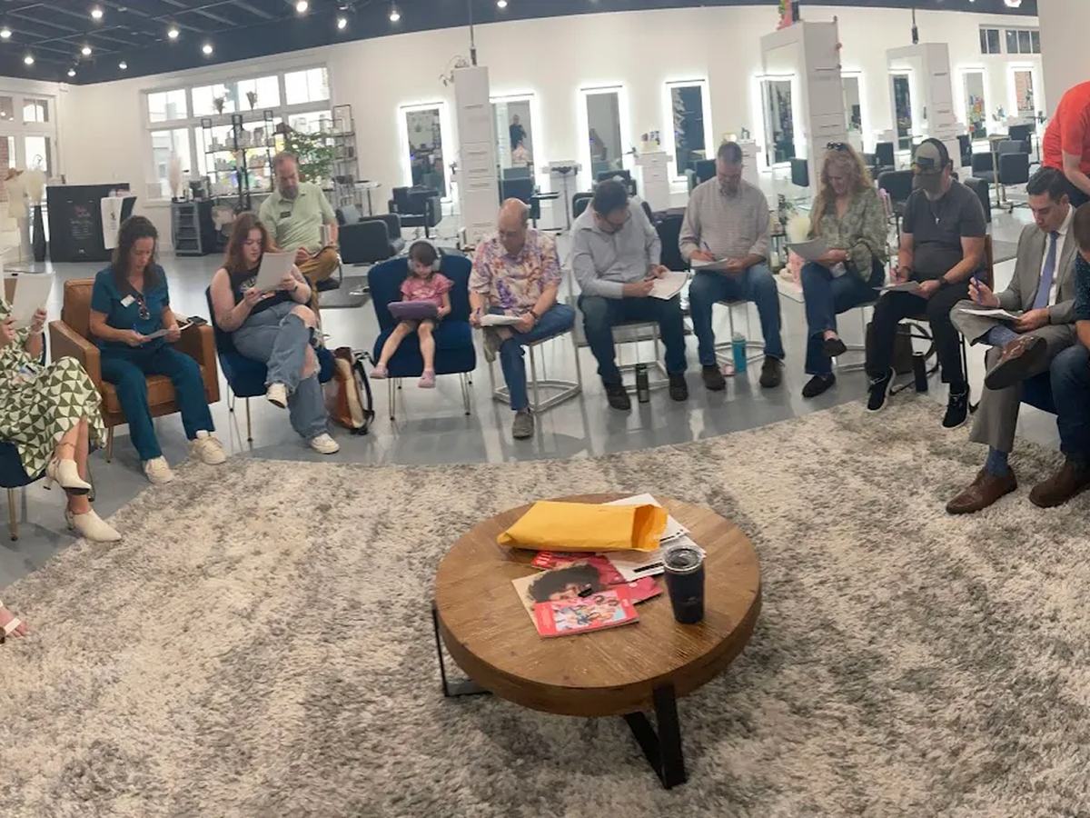 Business professionals seated in a wide circle of chairs during a group coaching and training session led by Coach Matt Kern.