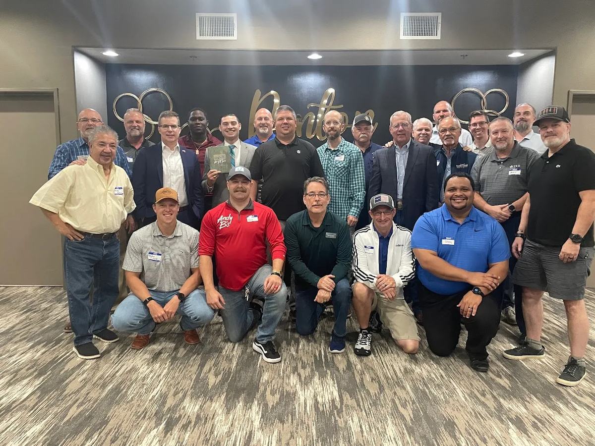 Large group of men standing and kneeling together for a photo at Coach Matt Kern&rsquo;s monthly men&rsquo;s breakfast in Denton, Texas.